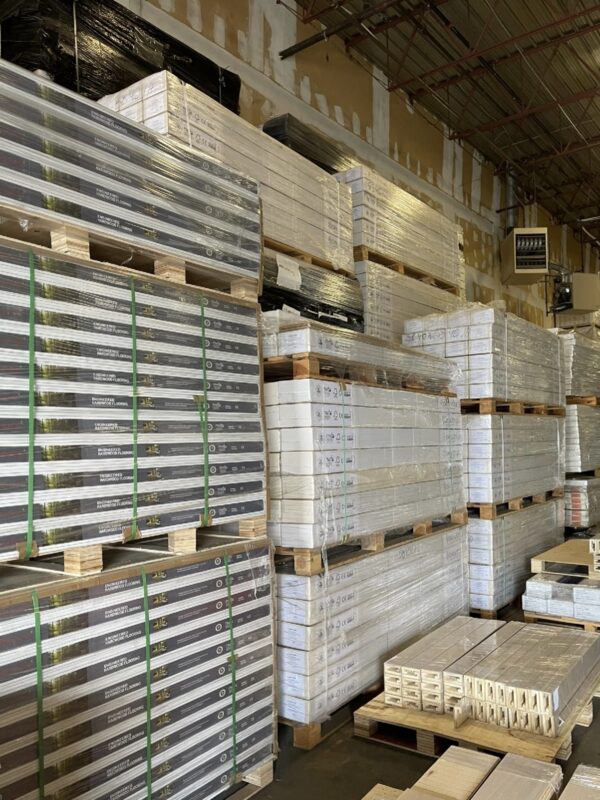 Finished wood flooring products stacked on pallets in a warehouse, representing inventory-heavy building materials storage