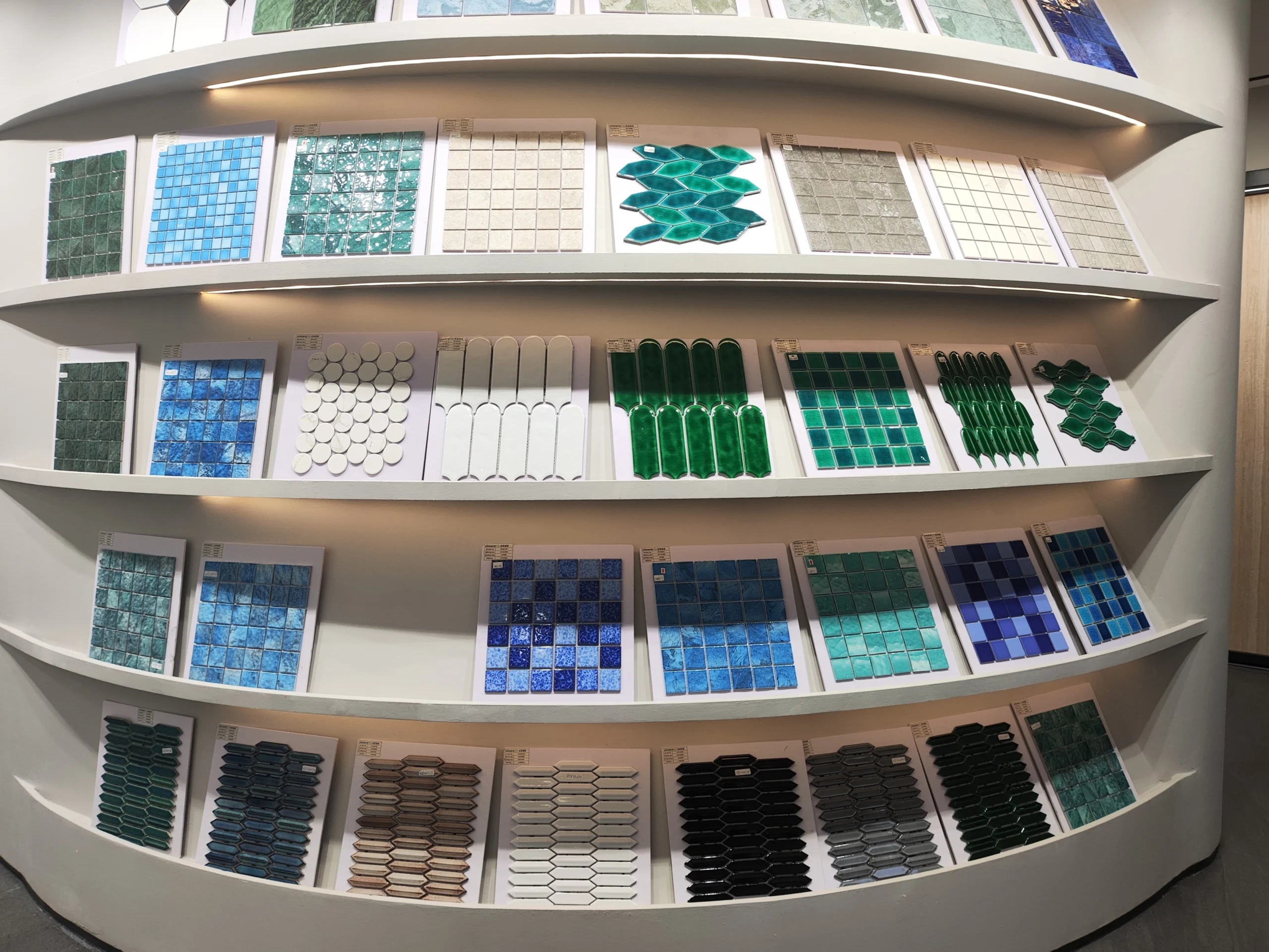 French Château Renovation: How We Sourced Furniture and Building Materials from China 6 Colorful mosaic tile samples in different shapes and finishes displayed on showroom shelves